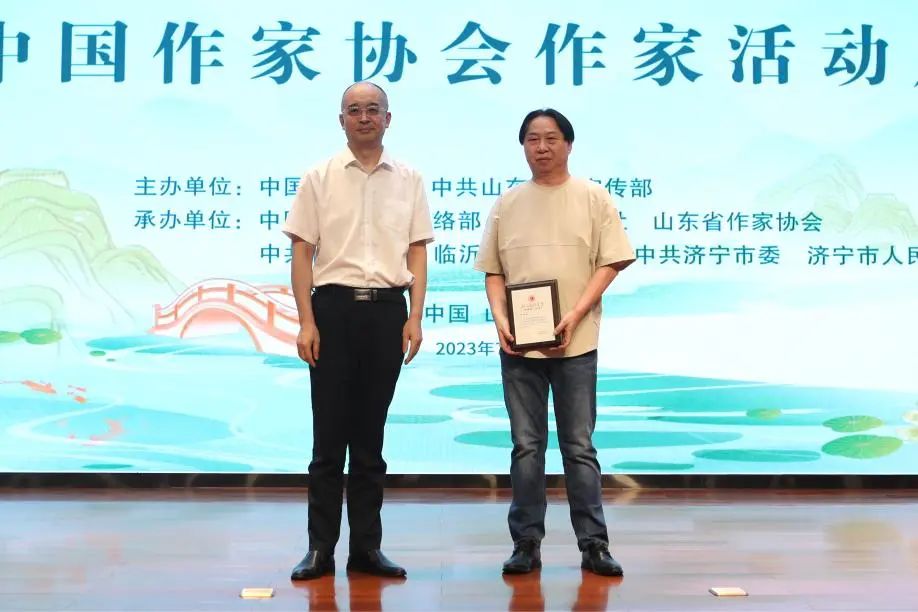 張宏森、吳義勤向參加此次“作家活動(dòng)周”的中國(guó)作協(xié)會(huì)員逐一頒發(fā)專屬“入會(huì)紀(jì)念牌”