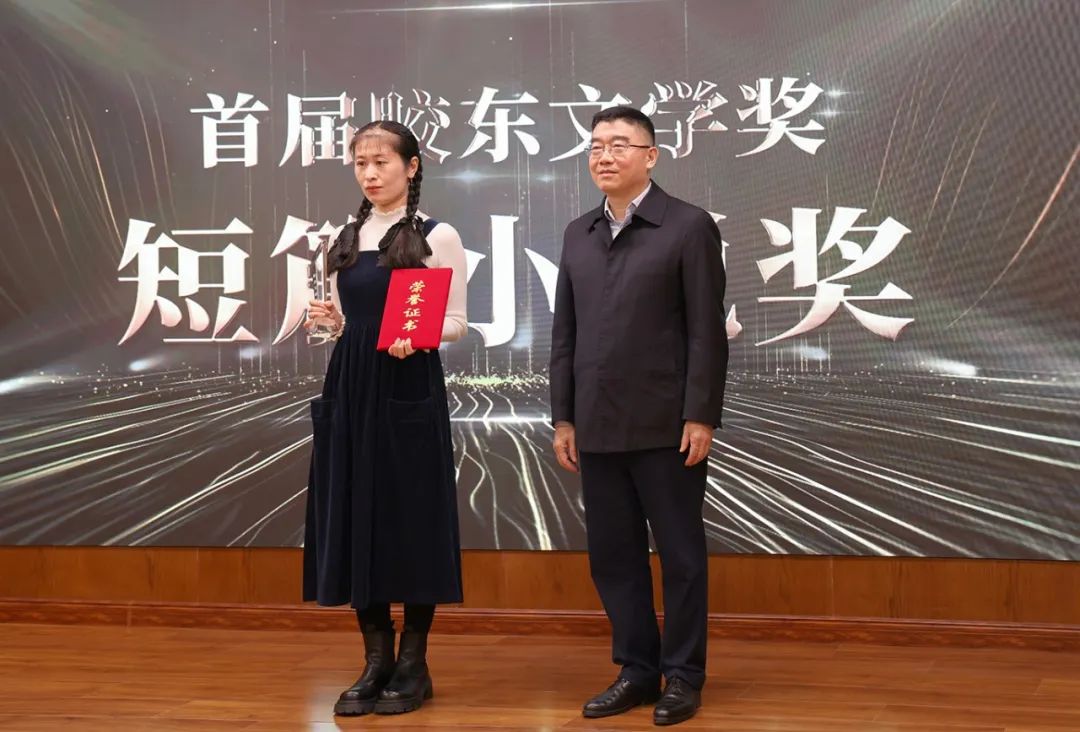 山東省作協黨組書記、副主席趙藝?。ㄓ乙唬? 為短篇小說獎獲得者王銘嬋頒獎