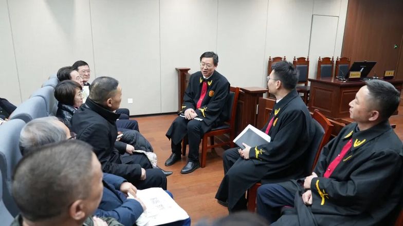 圖為采風(fēng)作家們?cè)诤戏史▌?wù)區(qū)旁聽庭審后，與主審法官交流。